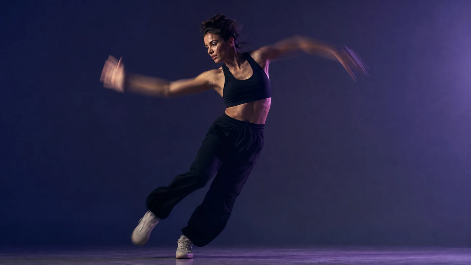 Dancer mid-step captured as a still frame with motion blur on the arms